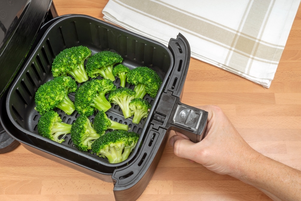 Hand,Cooking,Broccoli,Florets,In,Air,Fryer,At,The,Kitchen.