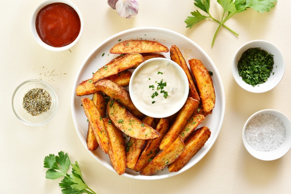 Oven,Baked,Potato,Wedges,With,Sauce,Over,Light,Stone,Background.