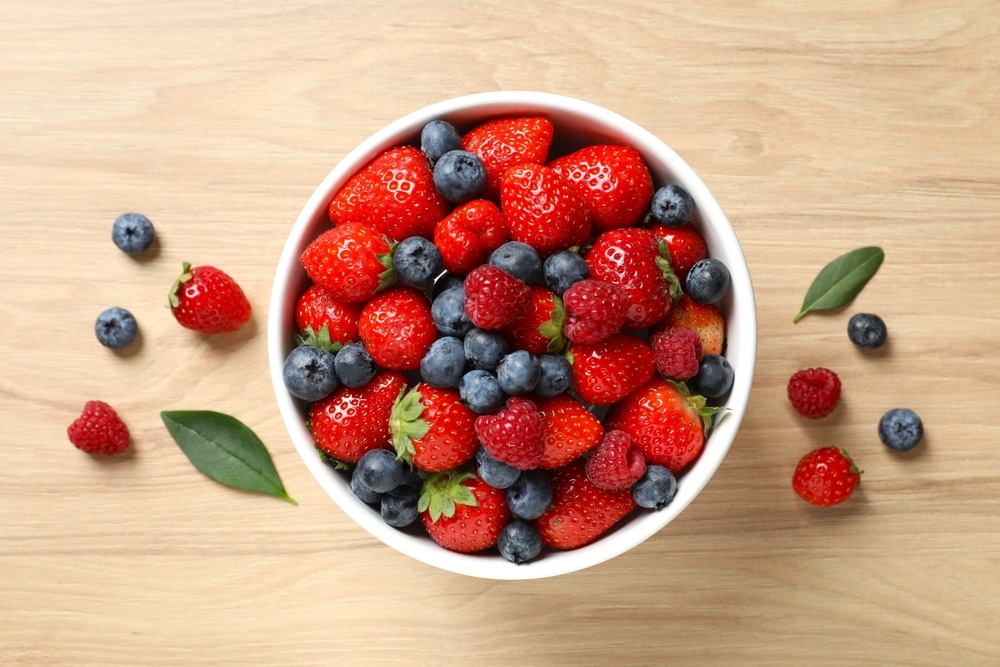 Different,Fresh,Ripe,Berries,In,Bowl,On,Wooden,Table,,Top