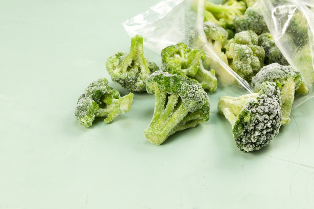 Frozen,Broccoli,Spilled,Out,Of,A,Plastic,Bag.,Light,Background