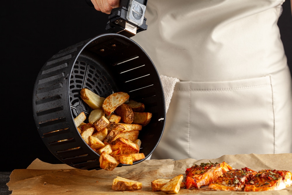 A,Caucasian,Woman,Chef,Is,Dumping,Fresh,Made,Fried,Potato