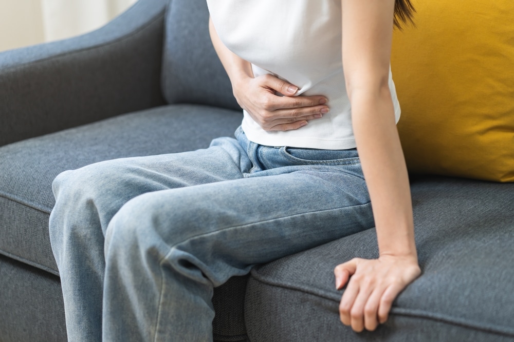 Sick,Asian,Young,Woman,In,Pain,,Hand,Holding,Belly,,Stomach