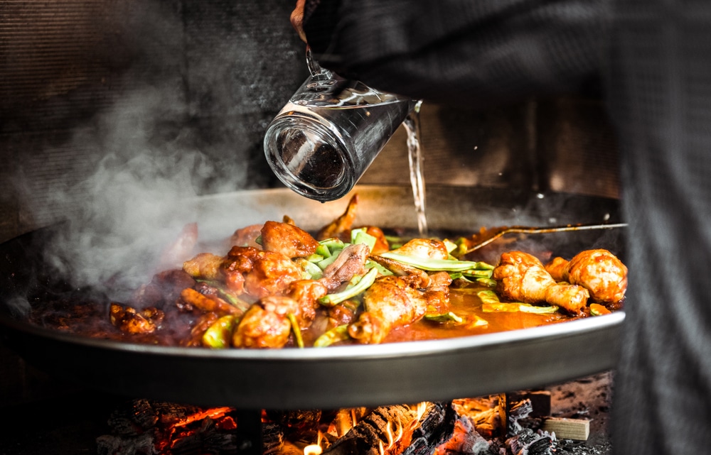 Cooking,And,Making,A,Traditional,Spanish,Paella,Over,Open,Fire.