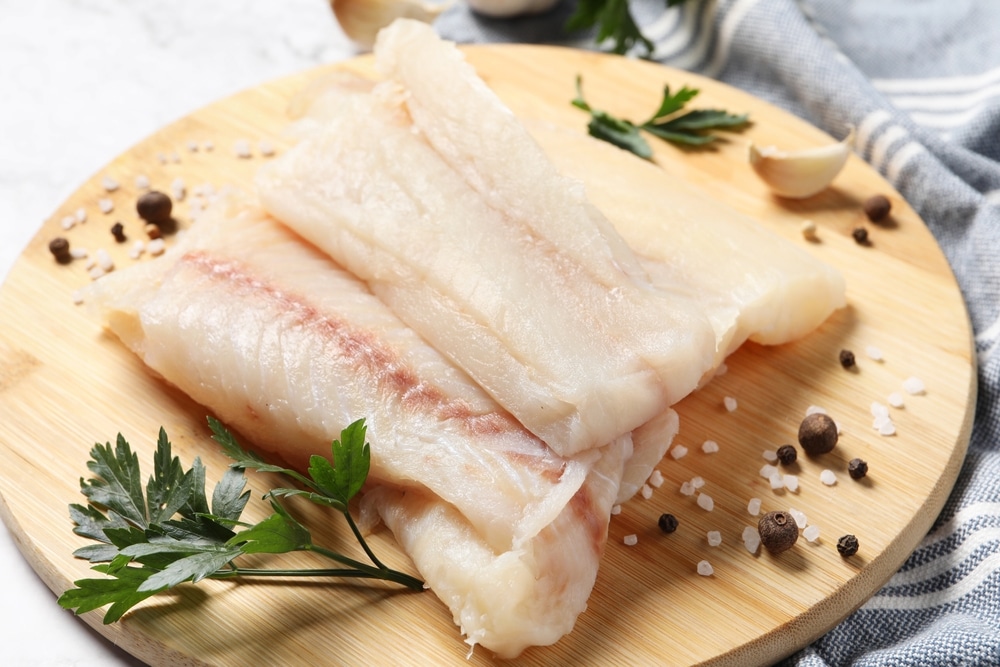 Pieces,Of,Raw,Cod,Fish,,Spices,And,Parsley,On,Table,