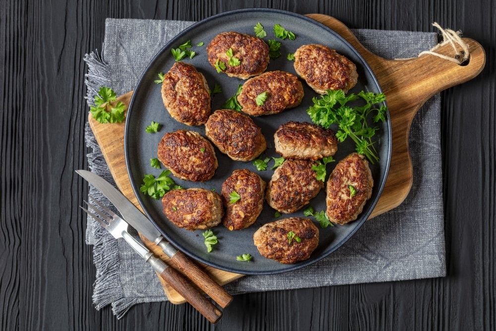 Frikadeller,,Danish,Meatballs,On,Grey,Plate,On,Cutting,Board,On