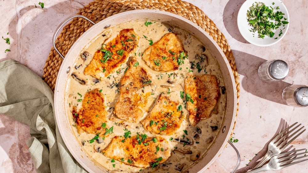 Creamy,Pork,Chops,In,Mushroom,Sauce,Sprinkled,With,Fresh,Herbs,