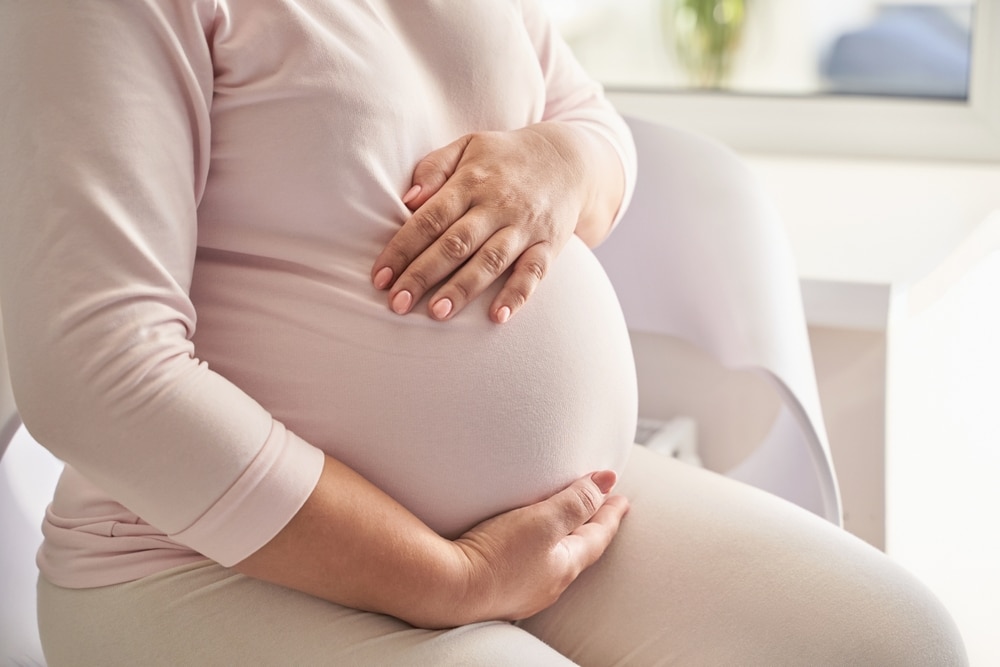 Pregnant,Caucasian,Young,Female,Sitting,On,Sofa,In,Comfortable,Home