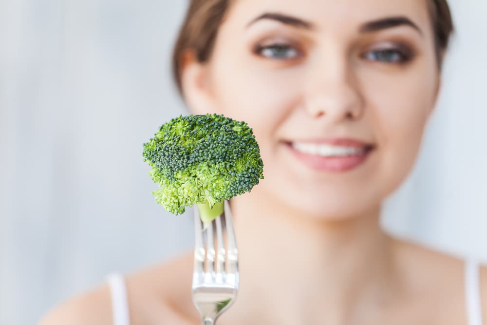 Portrait,Of,Happy,Smiling,Young,Beautiful,Woman,Eating,Broccoli